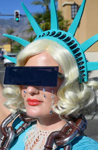 a woman dressed as the statue of liberty wearing sunglasses